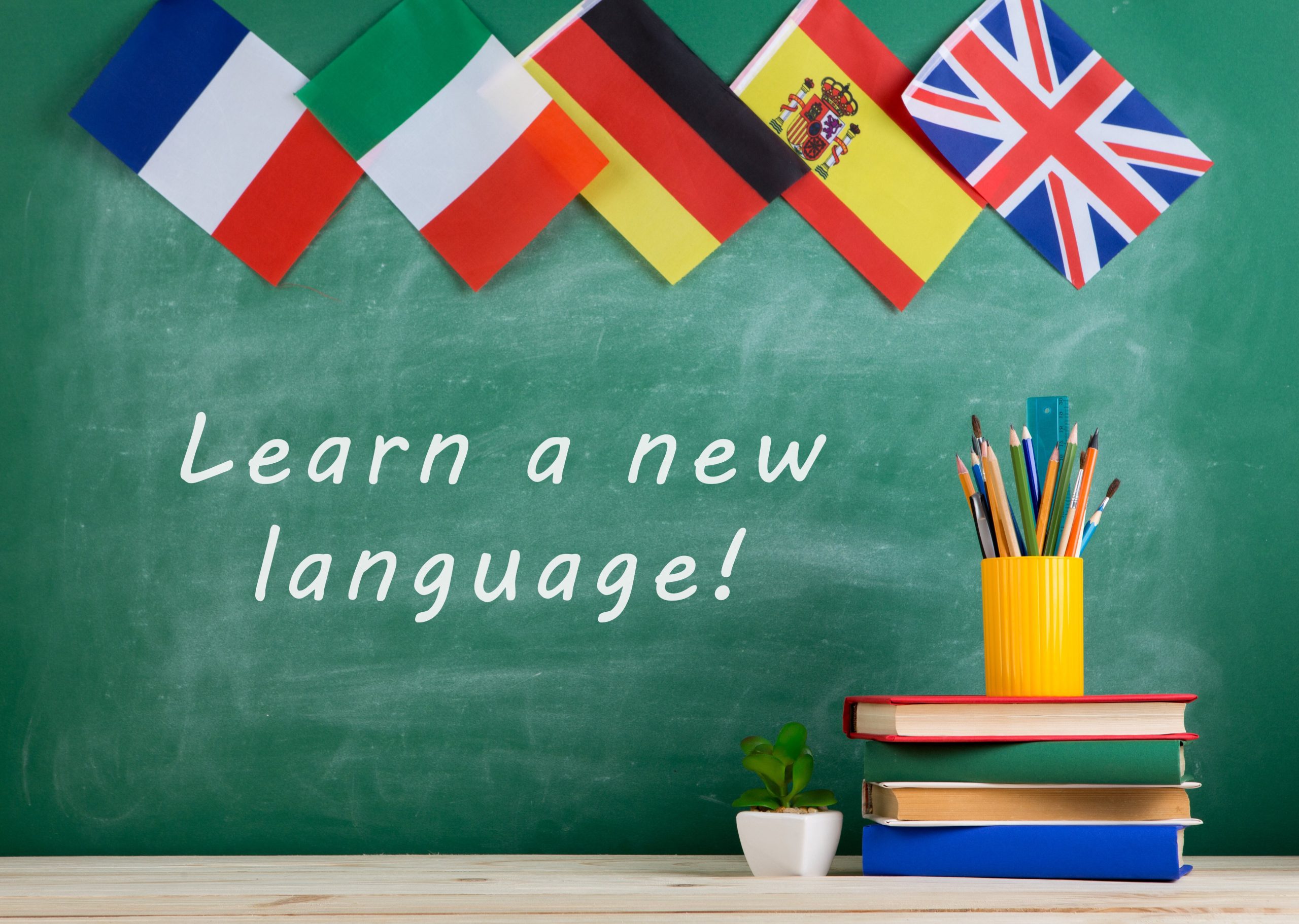 flags-spain-france-great-britain-other-countries-blackboard-with-text-learn-new-language (1)